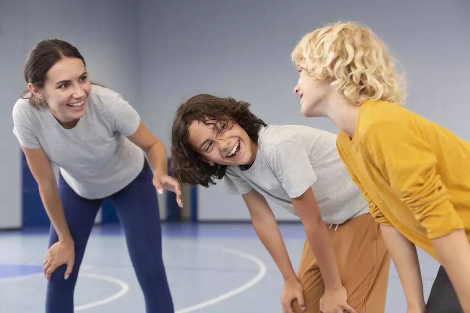 Sportlehrer mit den zwei Schülern