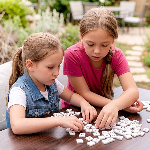 Zwei Mädchen spielen Buchstabensalat zur LRS‑Förderung